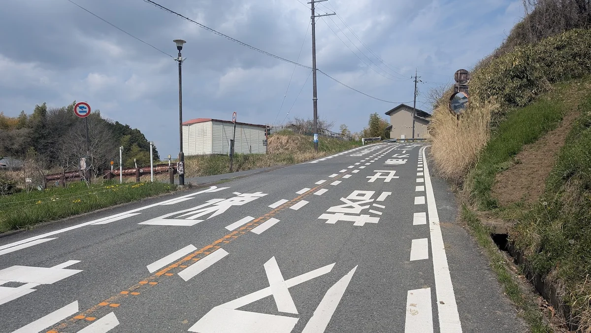石舞台方面から来た際、左側に白と朱色の屋根の小屋がある岡寺無料駐車場への分岐点