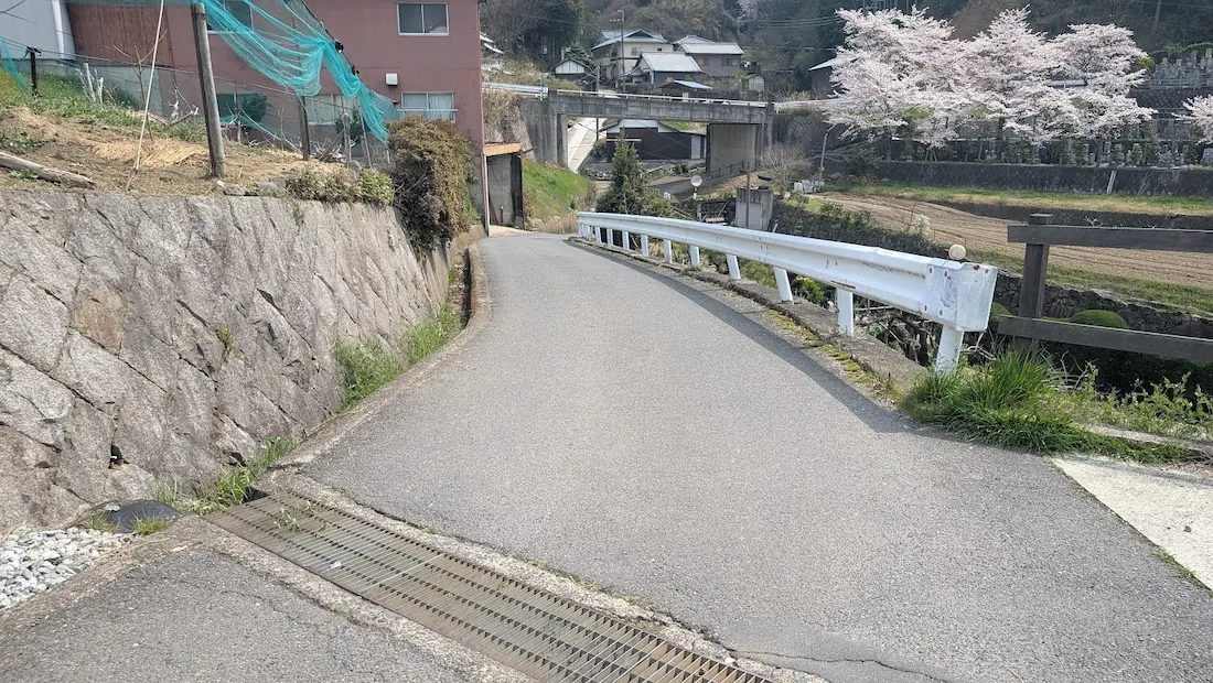 前方の道が下り坂になっている、カーブの続く狭い道