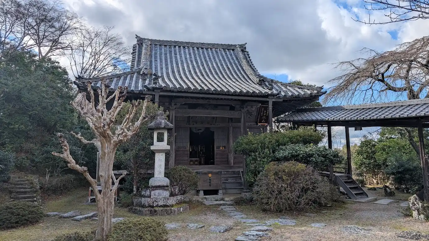 吉野山の宿坊「竹林院」の境内にある歴史を感じさせる木造の本堂と石灯籠、右手に続く趣深い渡り廊下