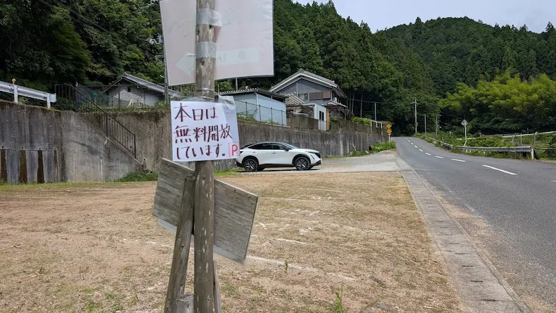 「本日は無料開放しています」と書かれた貼り紙がある長谷寺周辺の未舗装の無料駐車場全景。