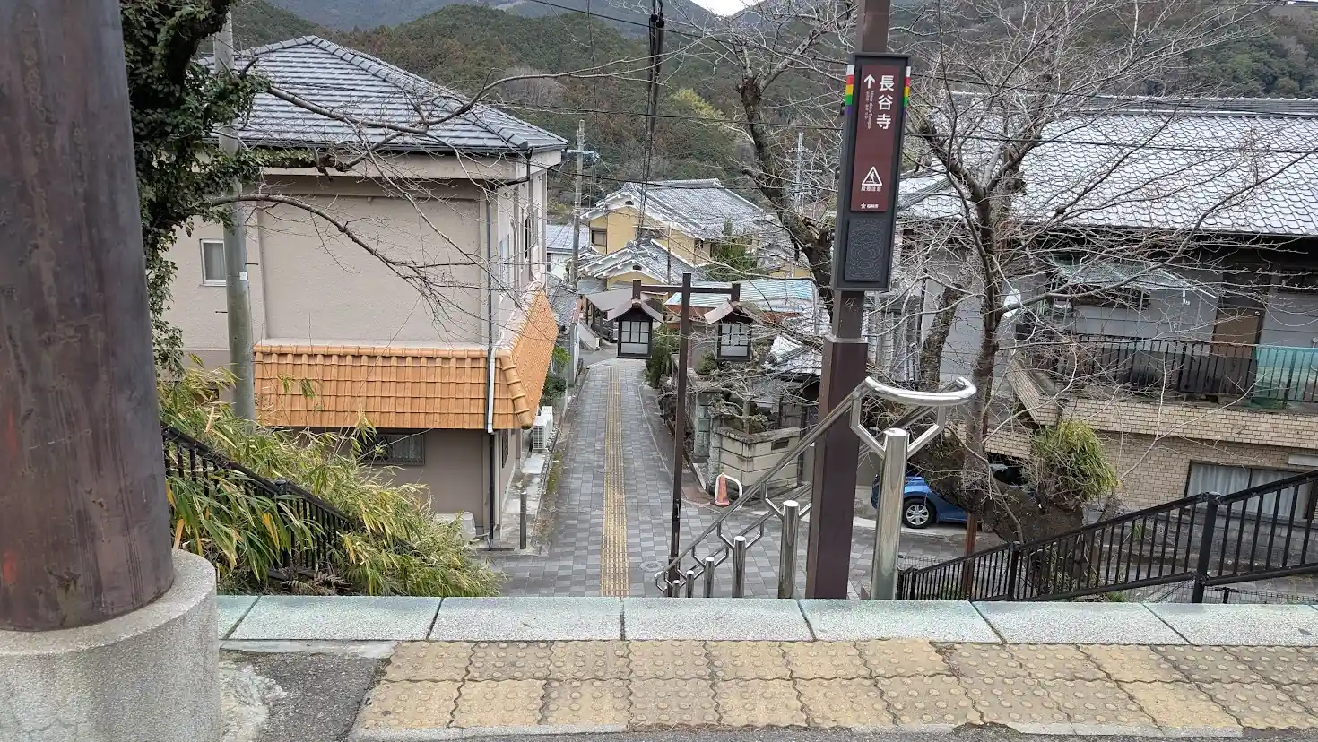 長谷寺駅から門前町へ向かって続く、下りの長い石段。手前には案内板があり、眼下には古い町並みが広がっている。