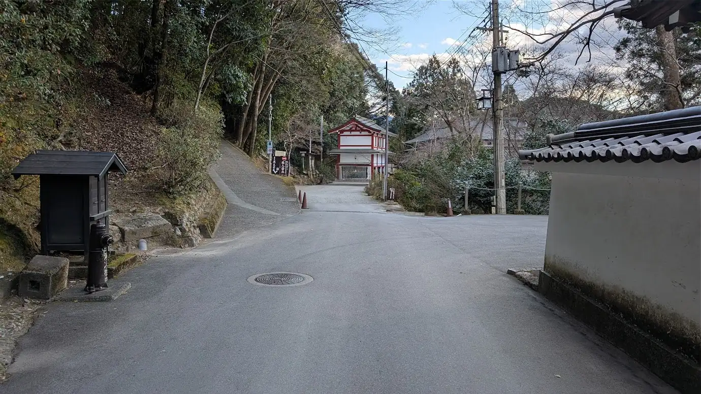 金峯山寺の駐車場分岐を左に進んだ先の風景。正面に見える赤と白の建物の手前が、冬の閑散期限定で利用できる蔵王堂横の駐車スペースへと続いている。