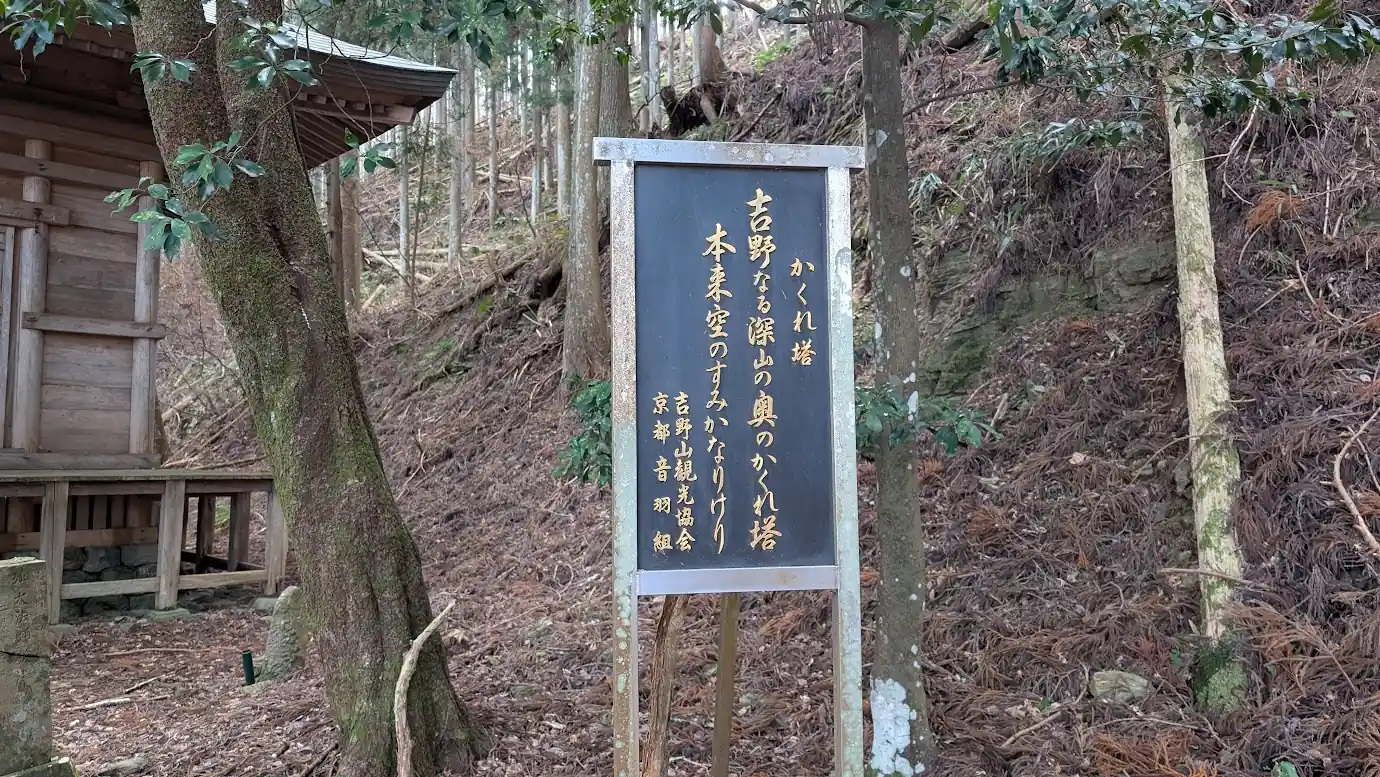 義経隠塔の和歌と由来が記された黒地の案内板
