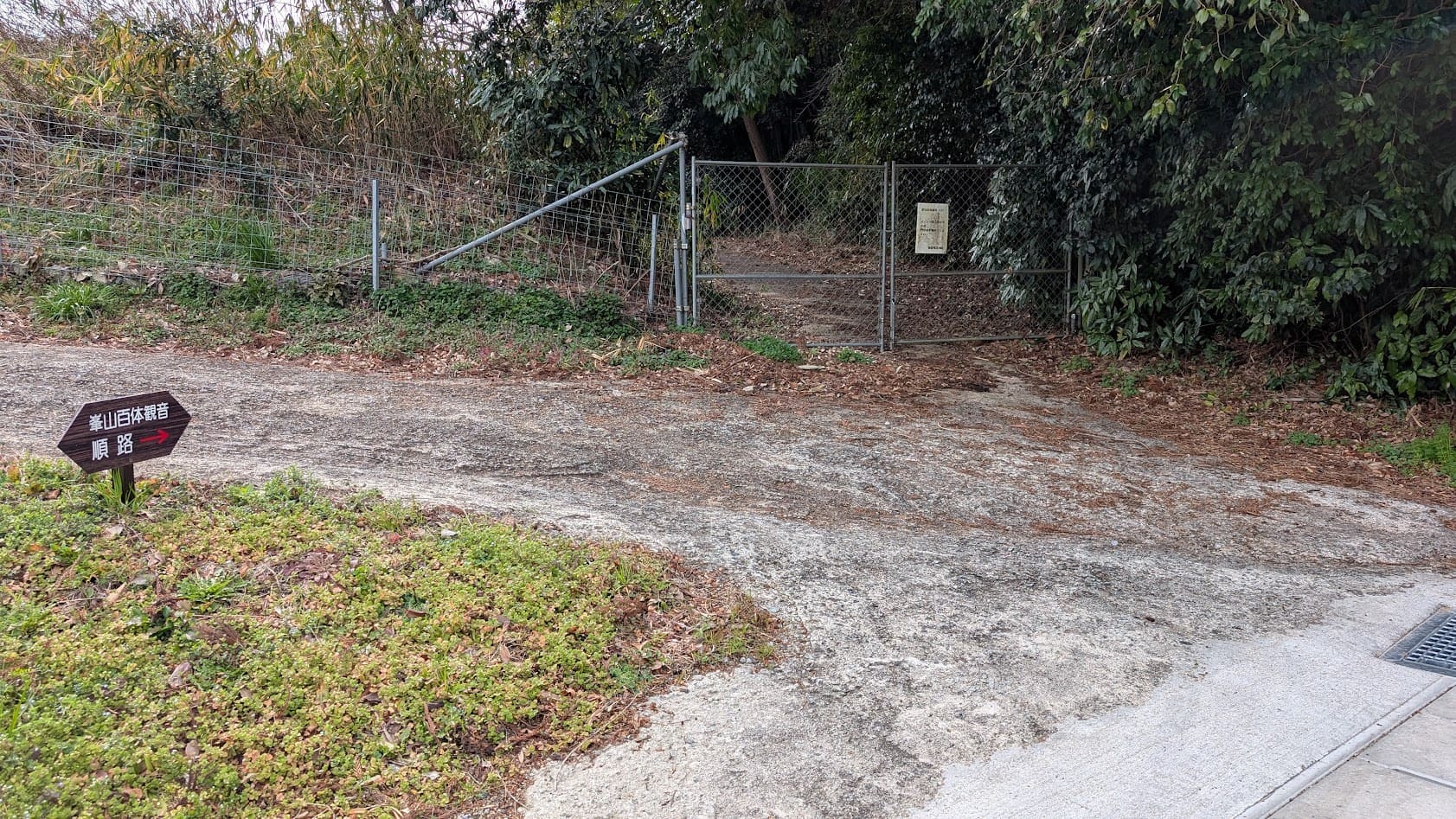 奈良県御所市・峯山百体観音の参道入口。イノシシ等の侵入を防ぐための鉄製フェンスと順路案内の標識。