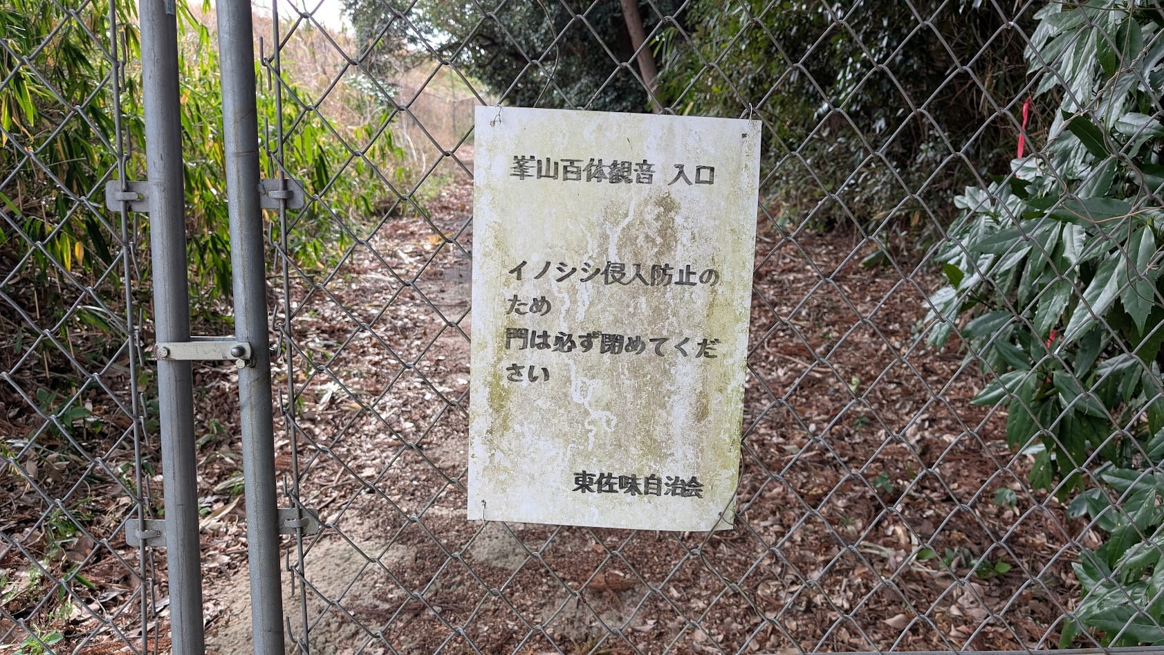 奈良県御所市・峯山百体観音の登山道入口。イノシシ等の侵入を防ぐための鉄製フェンスと注意書きの看板。