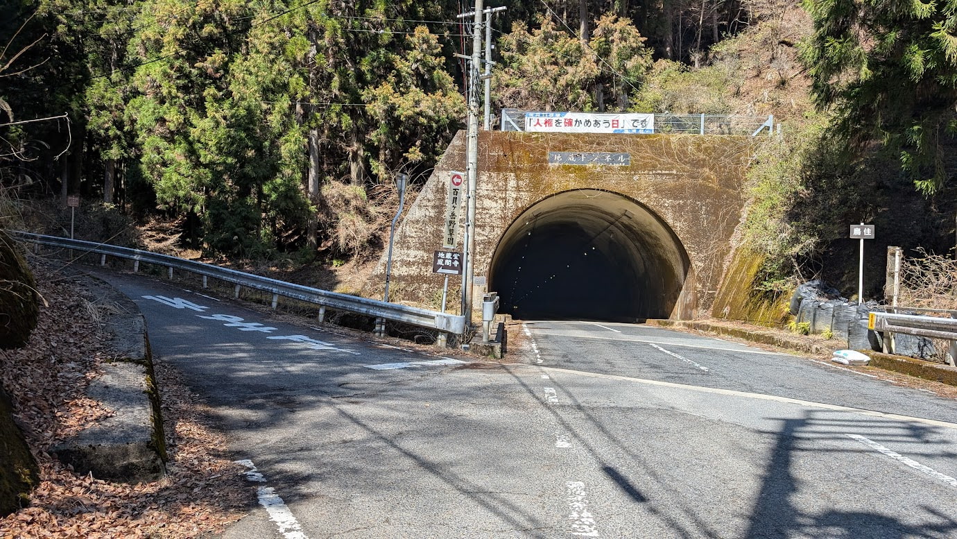 奈良県黒滝村にある鳥住春日神社と鳳閣寺への分岐点。左は下り坂、右は上り坂になっており、ガードレール沿いに小さな案内看板が立っている。周囲は深い山に囲まれている。