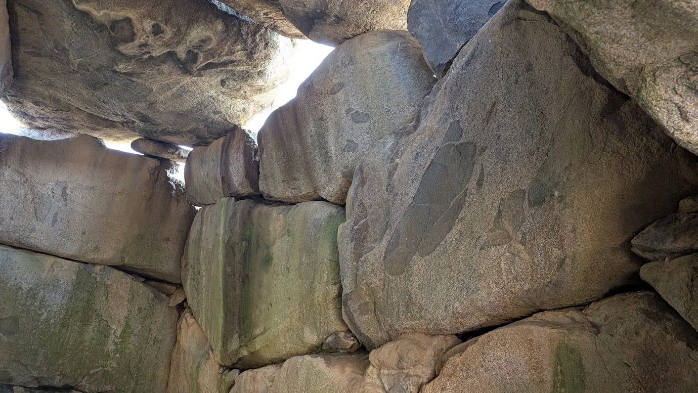 石舞台古墳の石室内部、入って左側の側面。1段目の巨大な石の上に、2段目以降は比較的小さな石を組み合わせて積み上げ、絶妙なバランスで壁面を構成している様子（2026年3月30日撮影）。