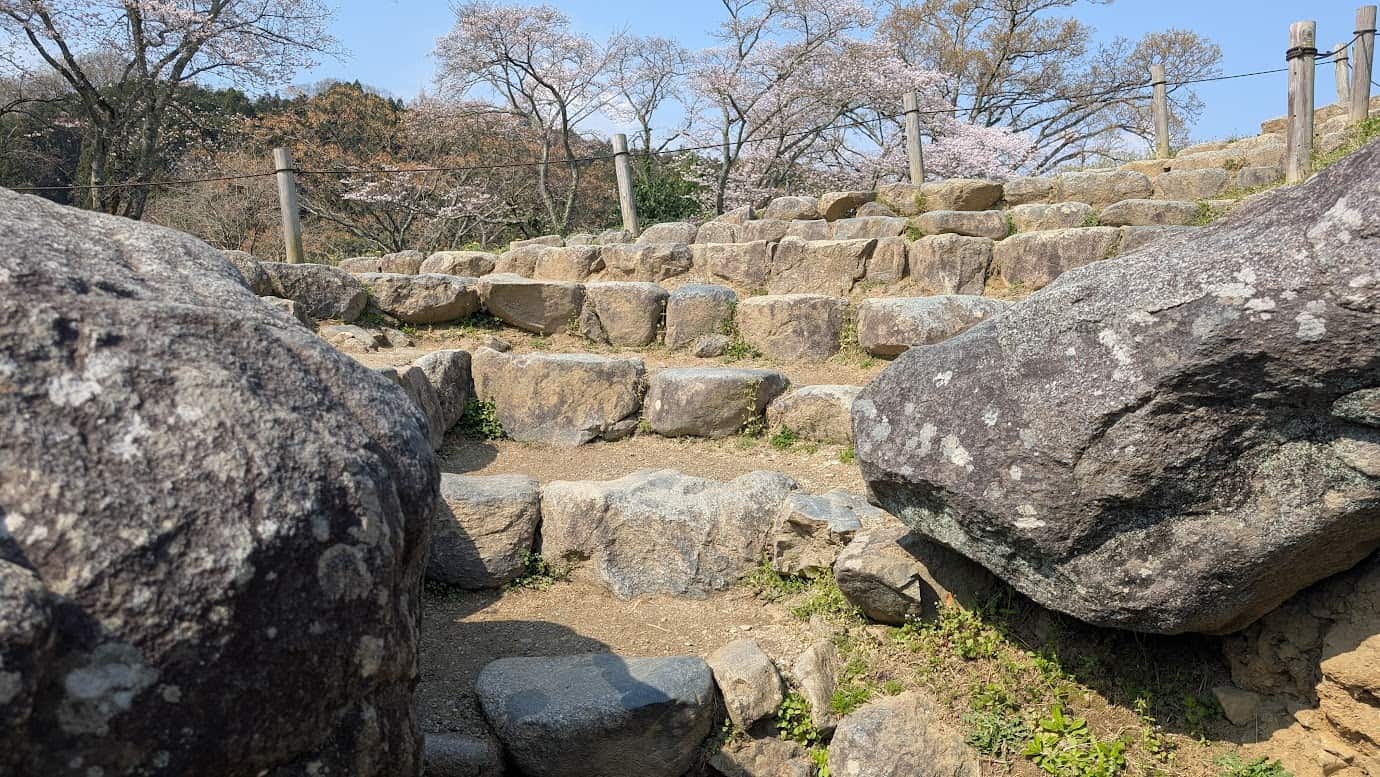 石舞台古墳の石室内部へ降りるための急で歩きにくい階段。岩を削り出したような不規則な段差で、足元に注意が必要な構造（2026年3月30日撮影）。