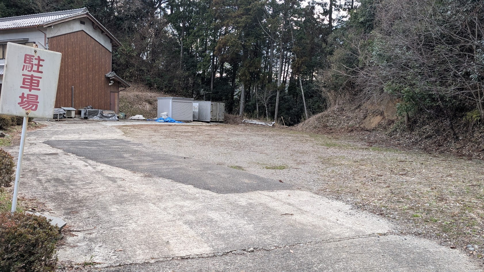 奈良県桜井市・瀧蔵神社の未舗装で白線のない砂利の駐車場。周囲を森に囲まれた広場のようなスペース。