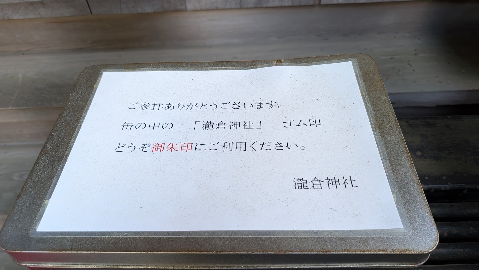 奈良県桜井市・瀧蔵神社の境内に置かれた、セルフサービスで拝受する御朱印の案内紙と、スタンプが入った缶の全体風景。