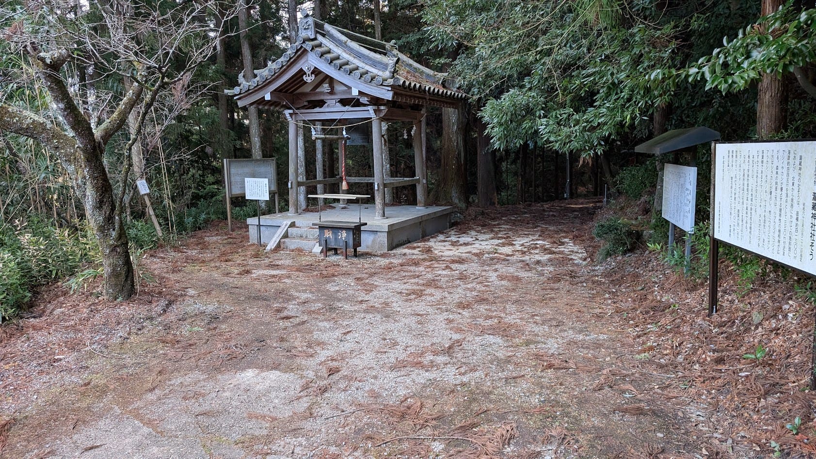 奈良県桜井市・瀧蔵神社の境内にある、歴史を感じさせる木造の鐘楼と、本殿へと続く参道の入口。