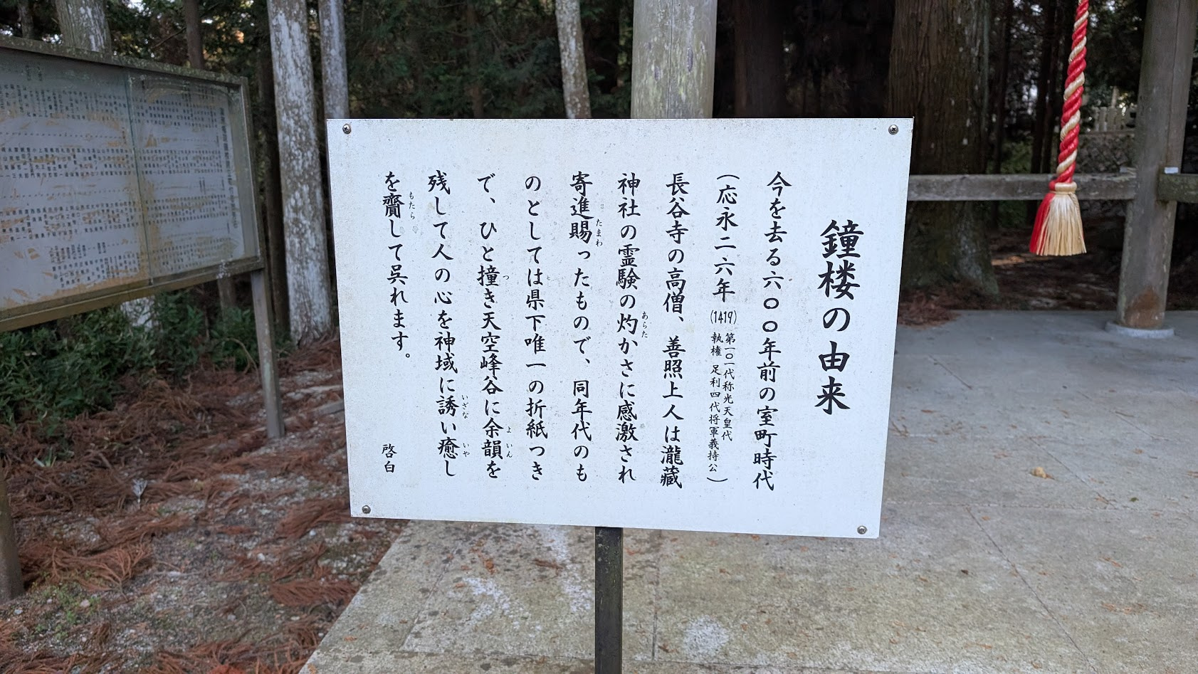 瀧蔵神社の鐘楼の由来や、長谷寺との歴史的な関わりについて記された木製の案内板。