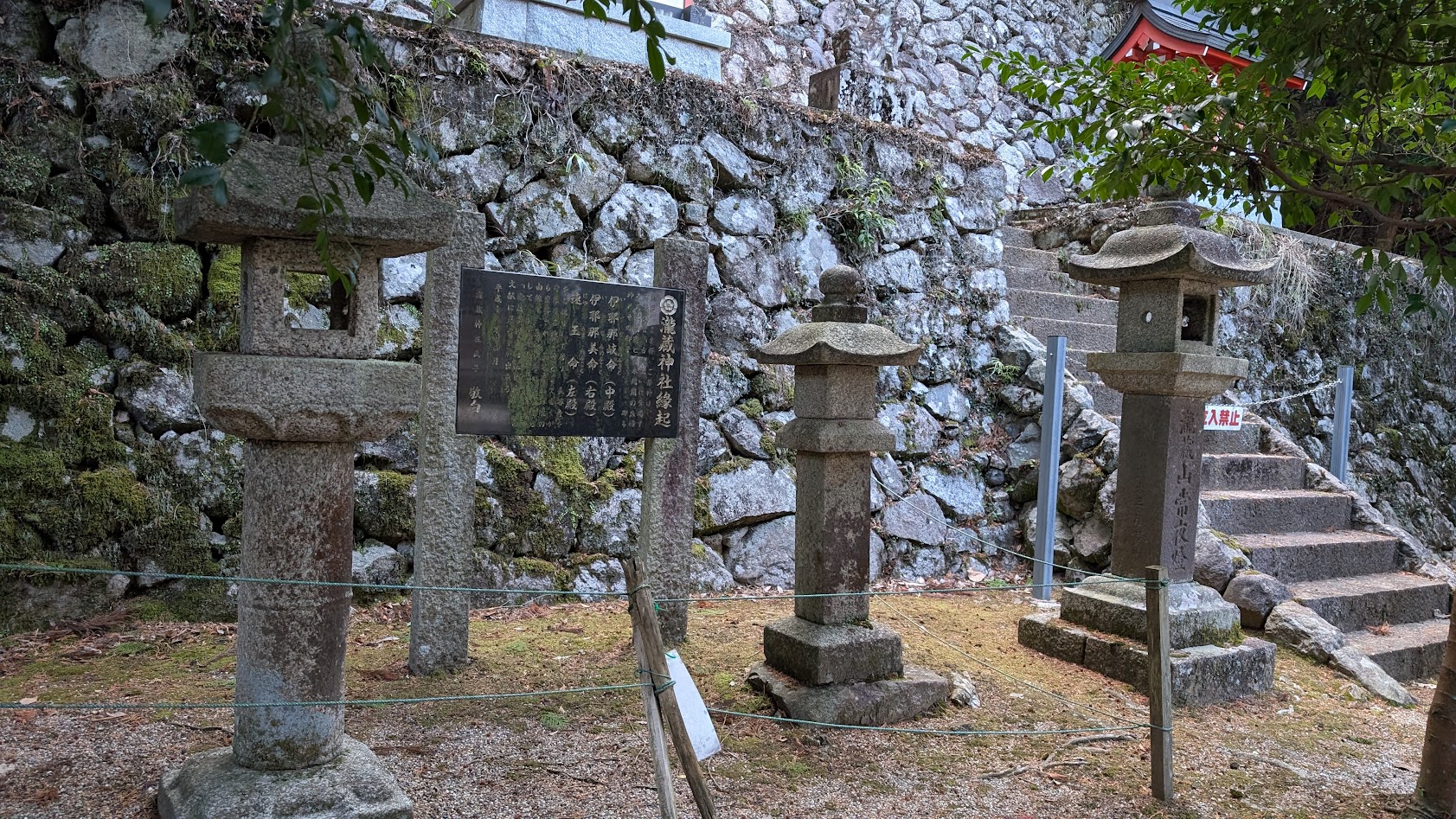 瀧蔵神社の境内に並んで立つ三体の古い石燈籠。それぞれに苔がむし、歴史を感じさせる佇まいの全景。