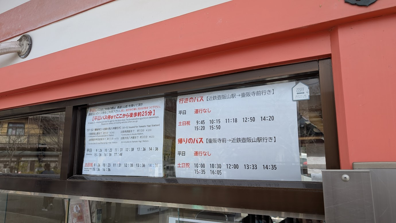 奈良・壷阪寺の入山受付横に掲示された、壺阪山駅行きのバス運行時刻表と詳細案内。