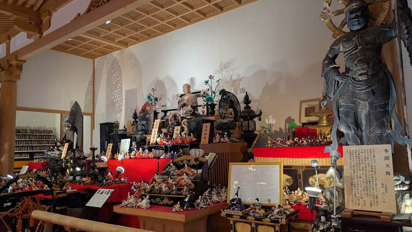 奈良・壷阪寺の大講堂。大日如来像や弘法大師像、多聞天像などの仏像と、周囲を埋め尽くすひな人形の共演。
