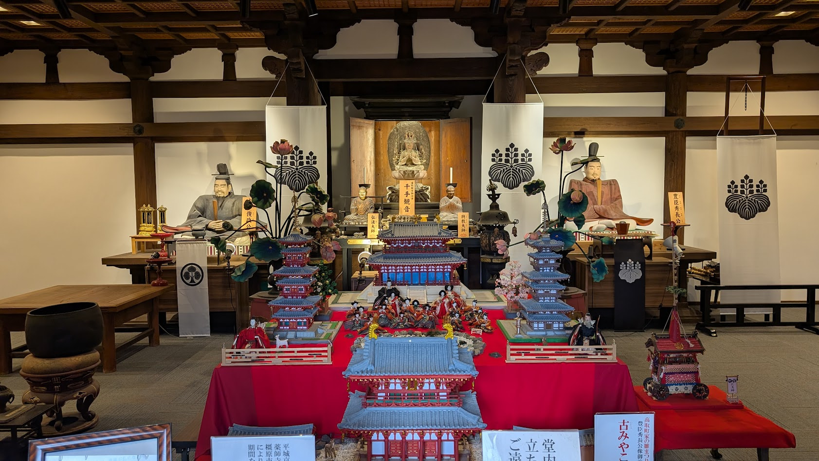 奈良・壷阪寺の灌頂堂内。千手観音菩薩像と豊臣秀長公像、そして周囲を彩る雛人形の全体風景。