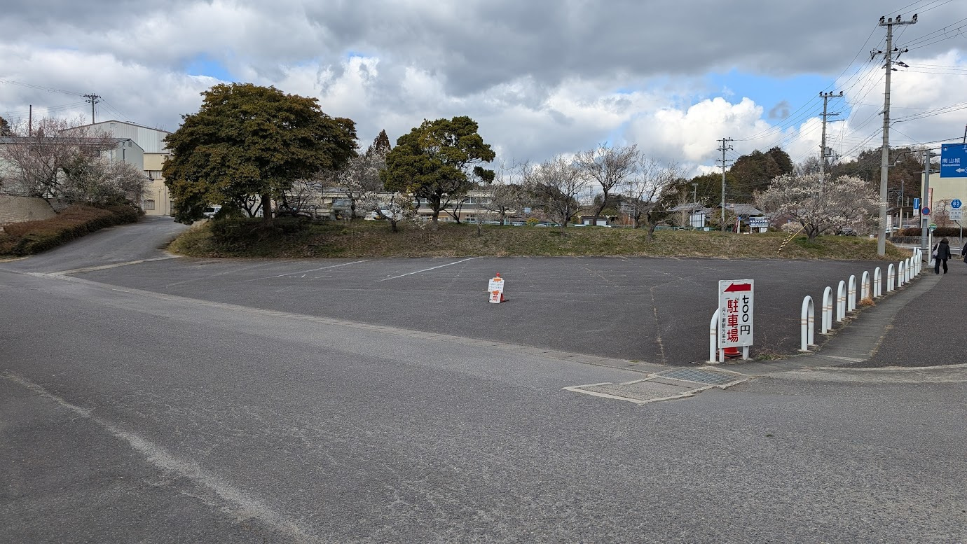 奈良県・月ヶ瀬梅林。行政センター・公民館の広大な第二駐車場。アスファルト舗装と白線が整備された駐車スペース。