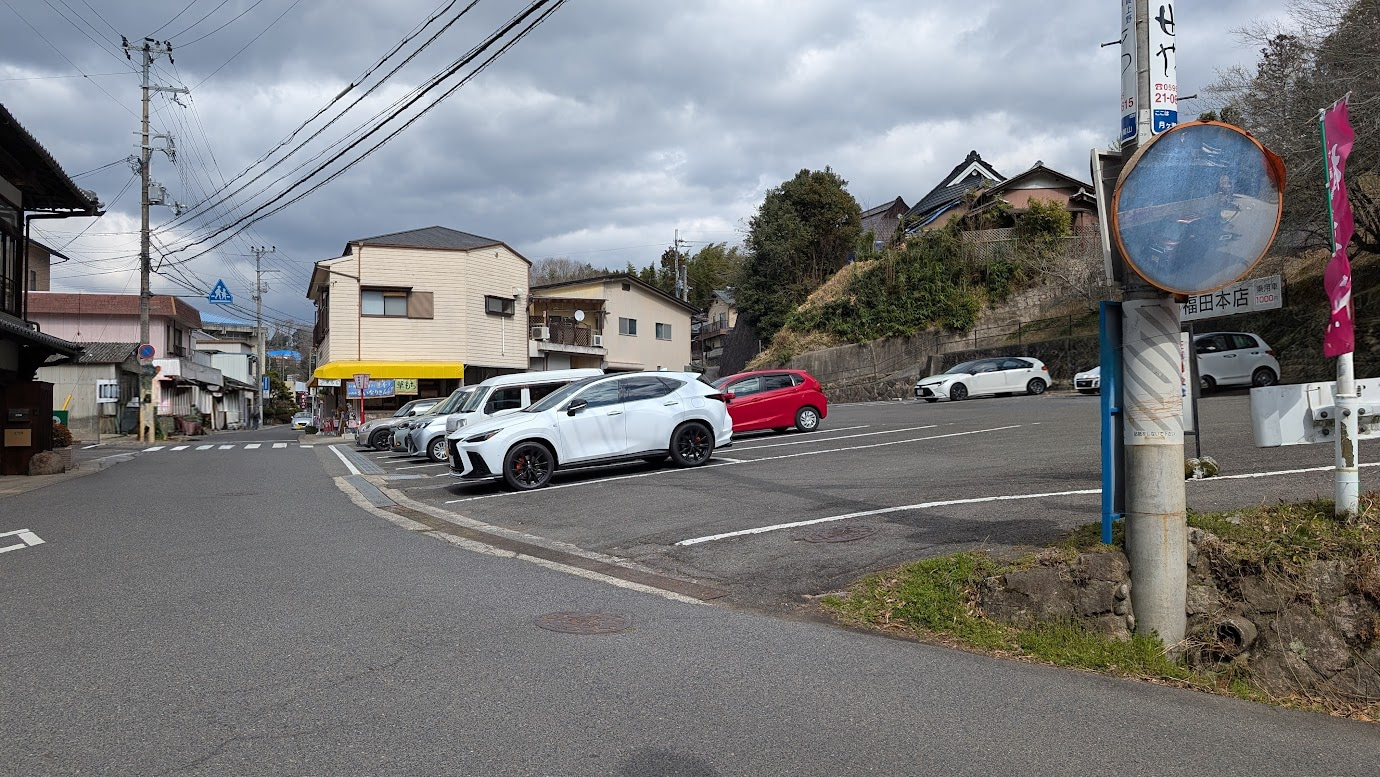 奈良県・月ヶ瀬梅林。石碑がある方山頂に二番目に近い。アスファルト舗装と白線が整備された福田本店の広々とした駐車場。