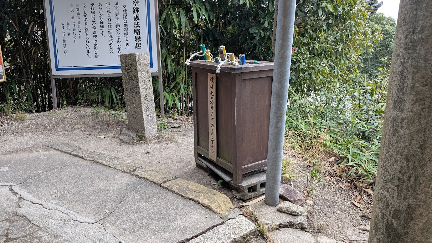 信貴山朝護孫子寺の入口付近にある、参拝者用の無料貸し出し杖。木の枝で作られた杖が木箱の中にたくさん入っている。