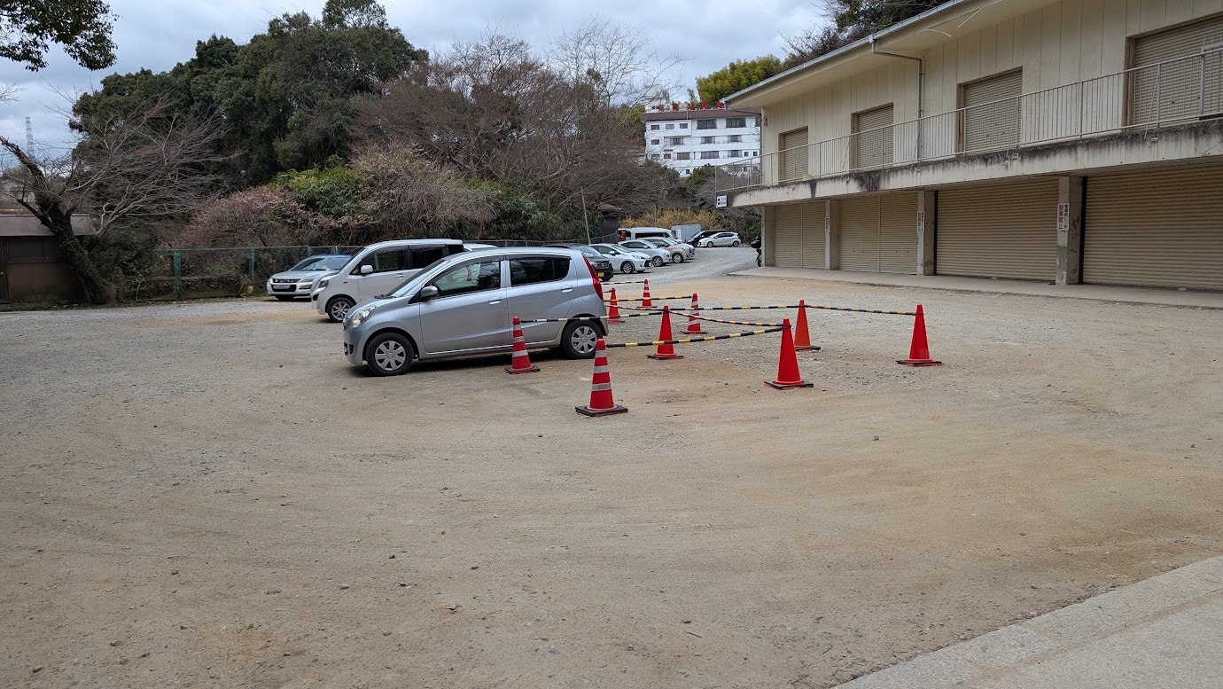 信貴山朝護孫子寺の第2駐車場。第1駐車場から少し坂を上がった場所にあり、白線がなく、砂利や土の未舗装の広い駐車スペース。