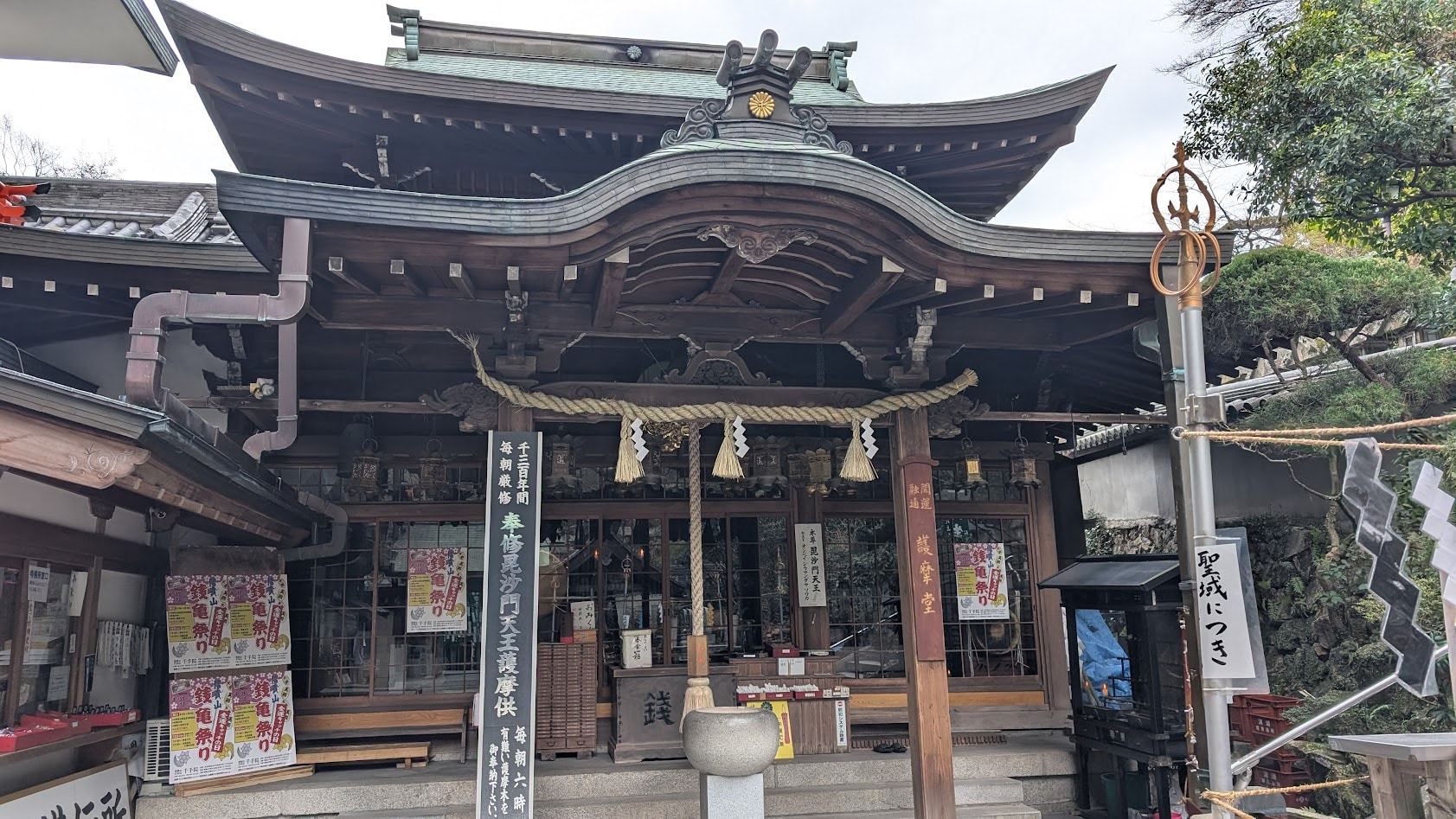 信貴山朝護孫子寺・千手院の護摩堂。歴史を感じさせる木造の堂宇で、入り口には護摩供の案内があり、周囲は落ち着いた宿坊の雰囲気に包まれている。