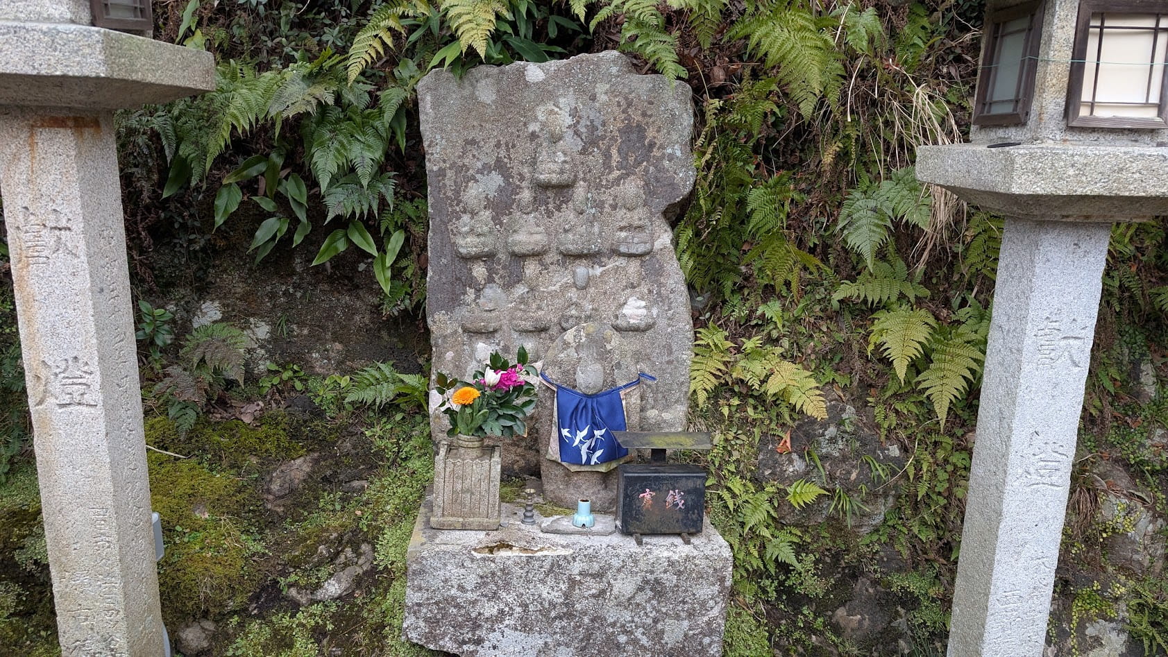 信貴山朝護孫子寺、千手院へ続く参道脇にある十三仏石龕。石の厨子の中に十三体の仏像が彫り込まれ、石肌が歴史を感じさせる。