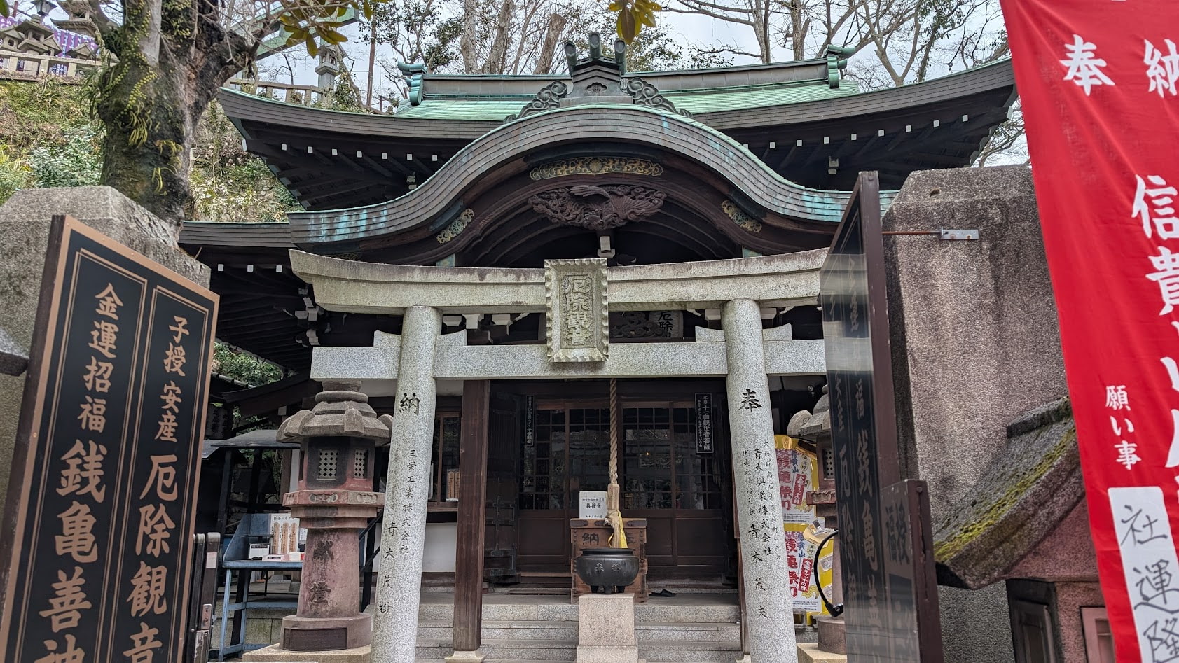 信貴山朝護孫子寺の厄除観音堂。木造の落ち着いた造りのお堂で、入り口には「厄除観音」の文字が見え、周囲は静かな参道の雰囲気に包まれている。