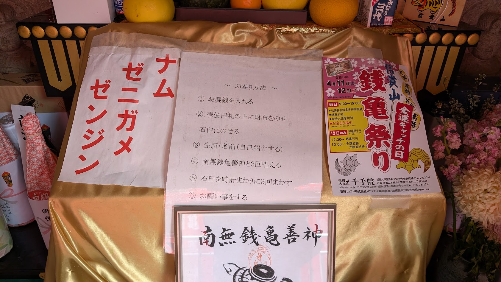 信貴山朝護孫子寺・銭亀堂内の参拝方法が書かれた貼り紙。①お賽銭を入れる、②壱億円札の上に財布をのせ、石臼にのせる、など全6ステップの作法が記載されている。