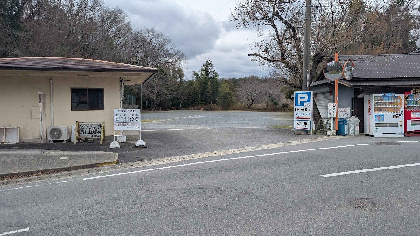 信貴山朝護孫子寺のすぐ向かいにある「山口モータープール」。砂利敷きの広いスペースに、かすかに残る区画線.1日500円の案内。