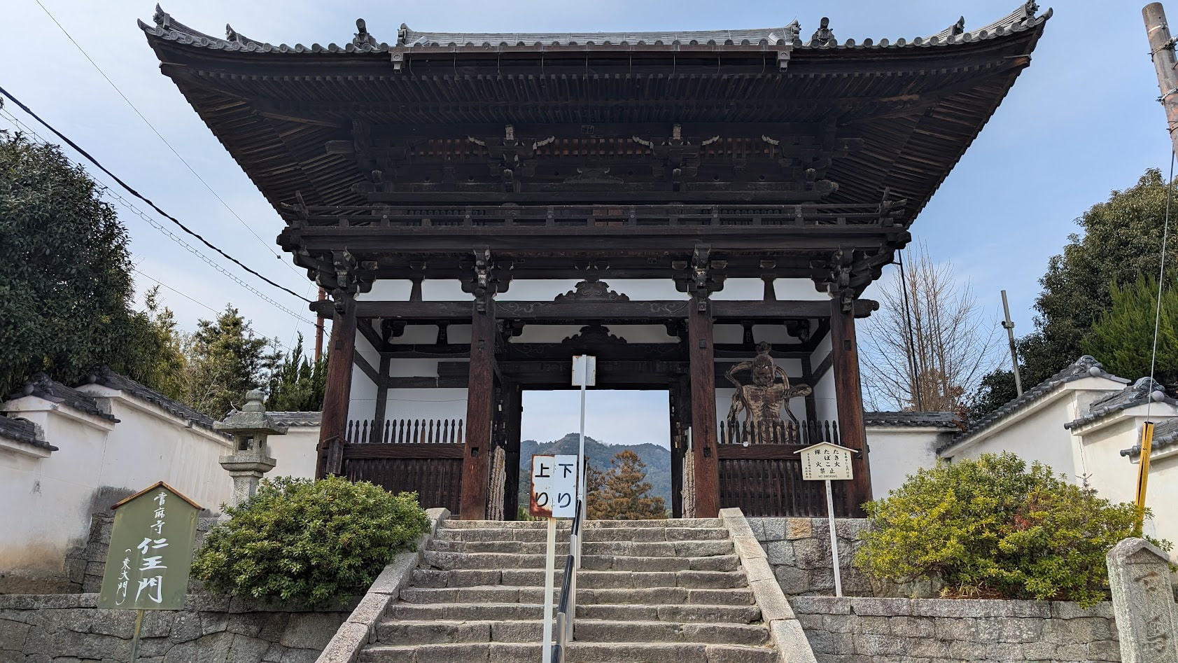 當麻寺の入り口にそびえ立つ、重厚な木造の仁王門。左右に安置された金剛力士像が参拝者を迎える、威厳ある正面全景です。