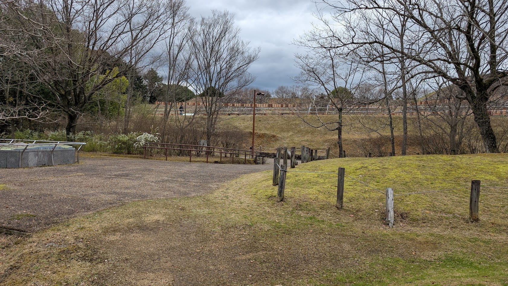 奈良県馬見丘陵公園のナガレ山古墳。復元された前方後円墳の斜面には円筒埴輪が列をなして並び、頂上へと続く階段と青空が見える。