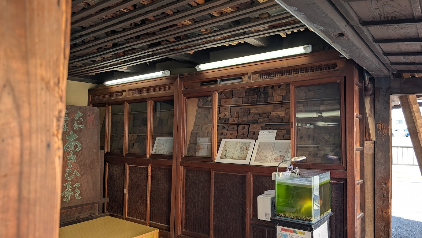 本家菊屋の店内に展示されている、古い木製の菓子型（木型）。様々な形や模様の木型が、時代を経て味わいを増した木の棚に所狭しと並んでいる。