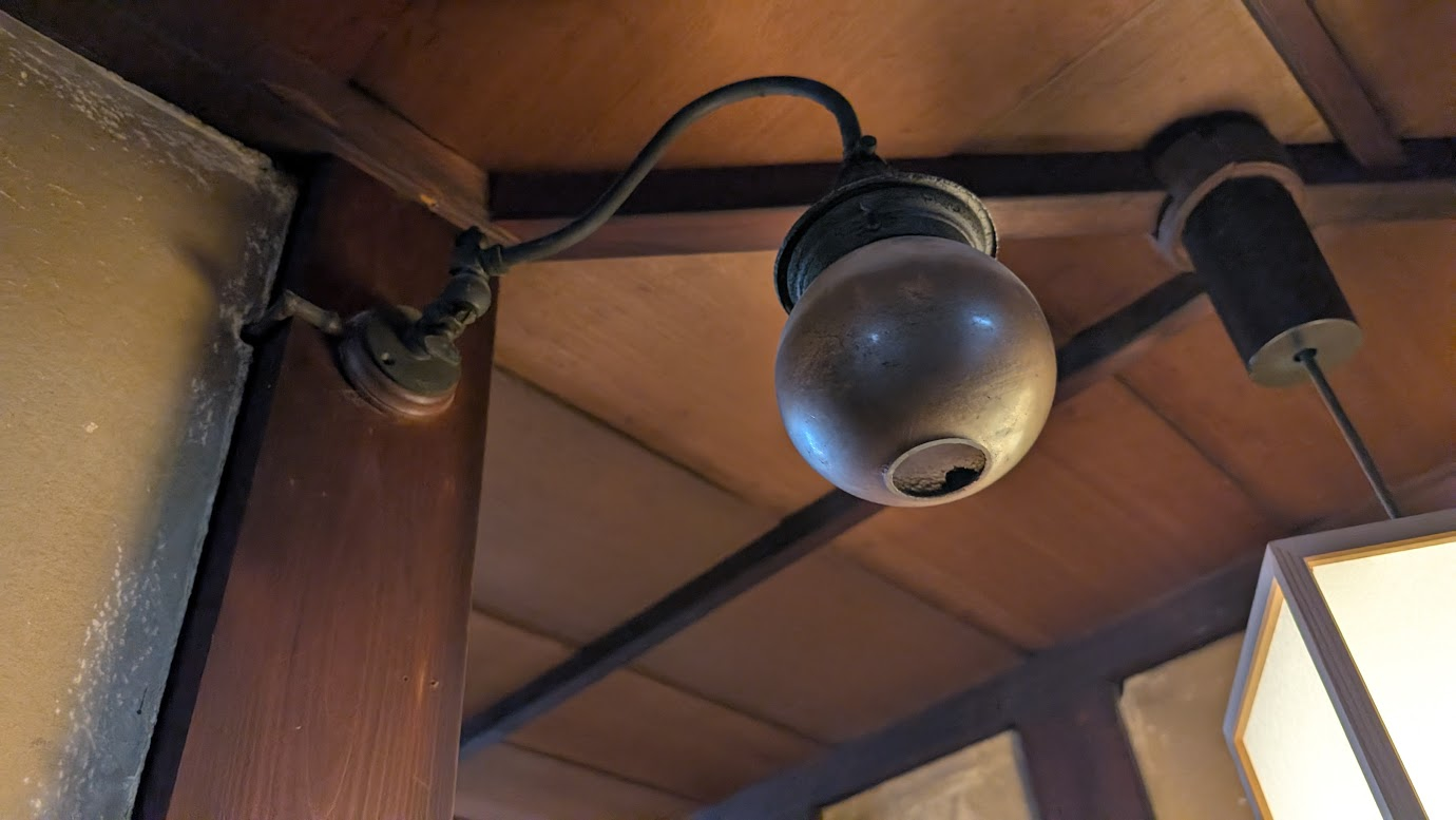 奈良県大和郡山市の町家物語館（旧遊郭建築）にある、大正・昭和初期のガス灯。丸いガラスシェードが天井の梁から吊り下げられており、レトロな雰囲気を醸し出している。