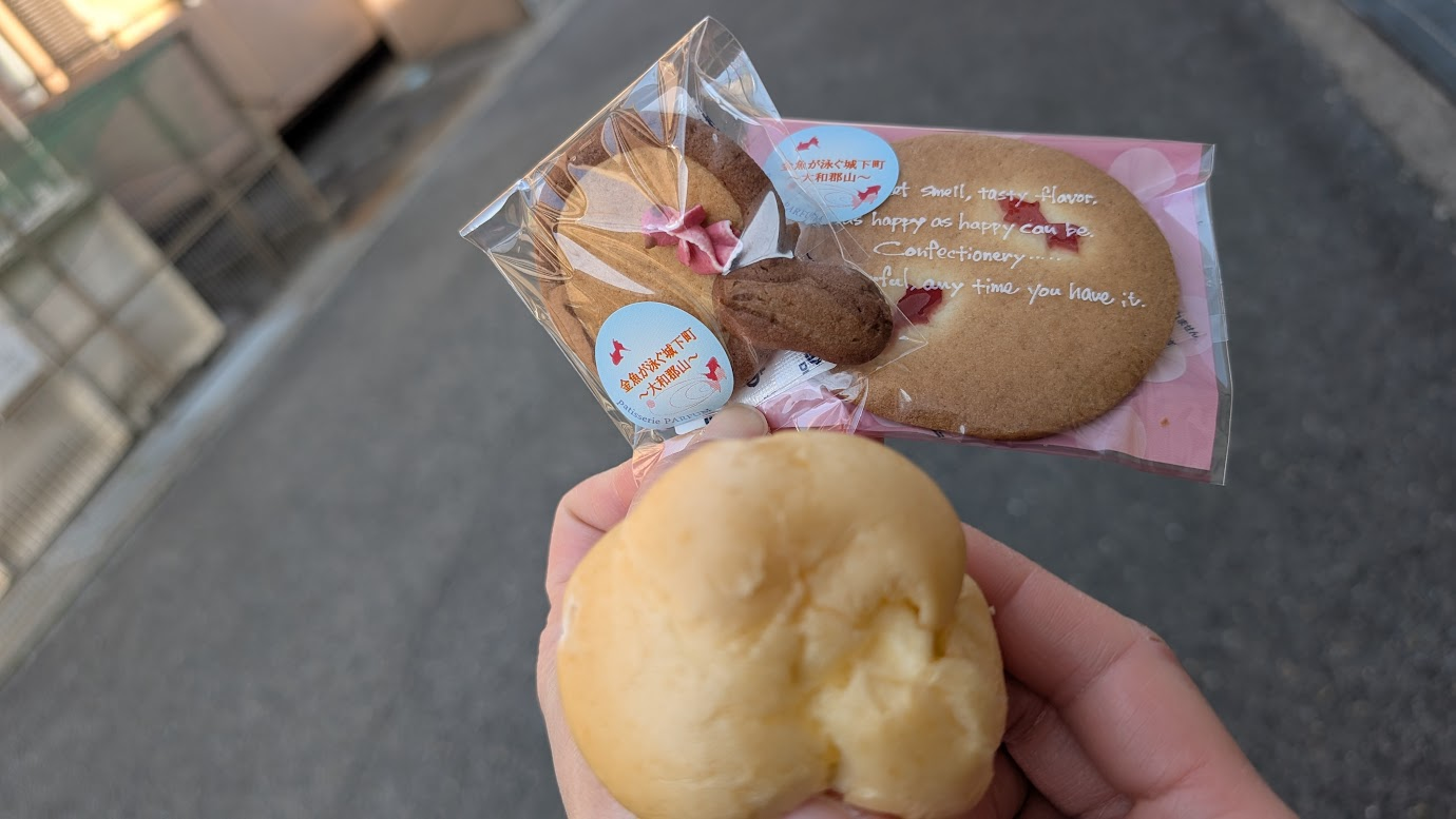 パルファンの「ぜんっぴんシュークリーム」と、ポイの形をしたクッキー、金魚の絵が入った可愛いクッキーが、鮮やかな青い「ポイ」の上に並べられている。