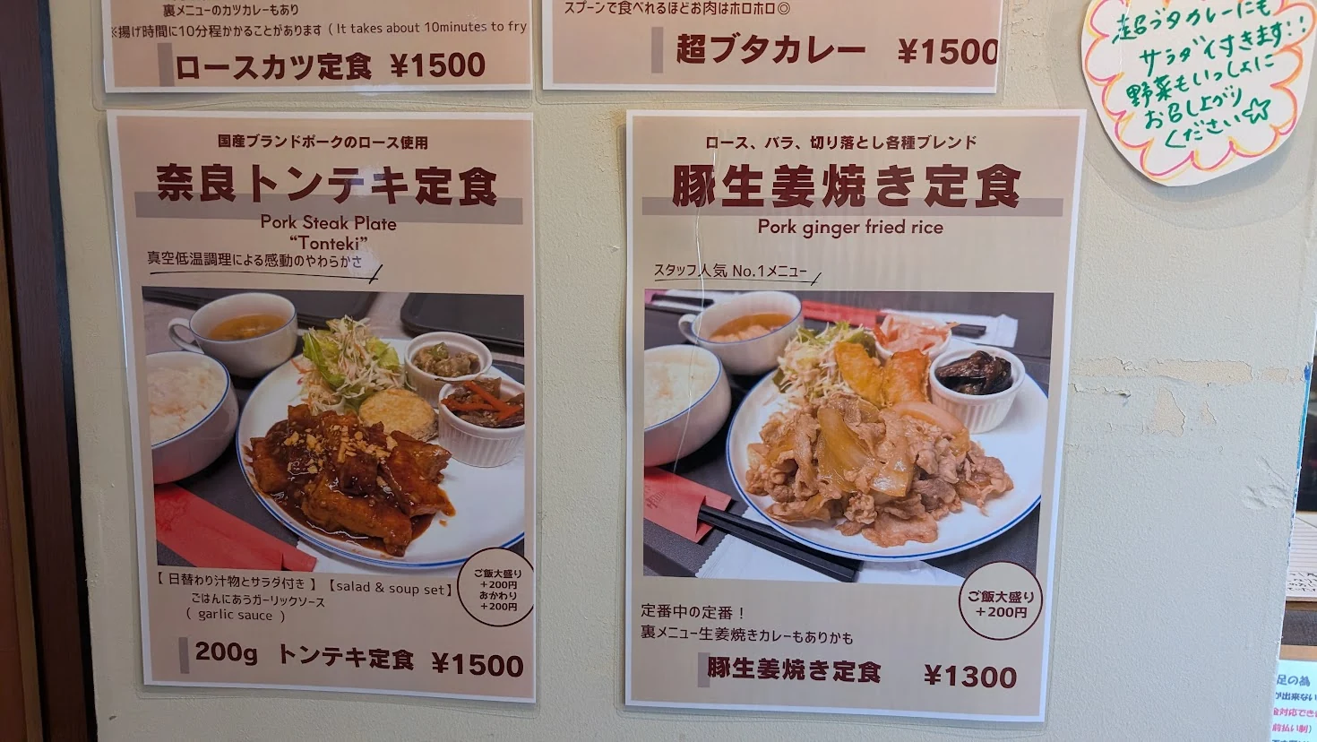 壁に掲示された「奈良トンテキ定食」と、スタッフ人気No.1の「豚生姜焼き定食」の写真付きメニュー表。
