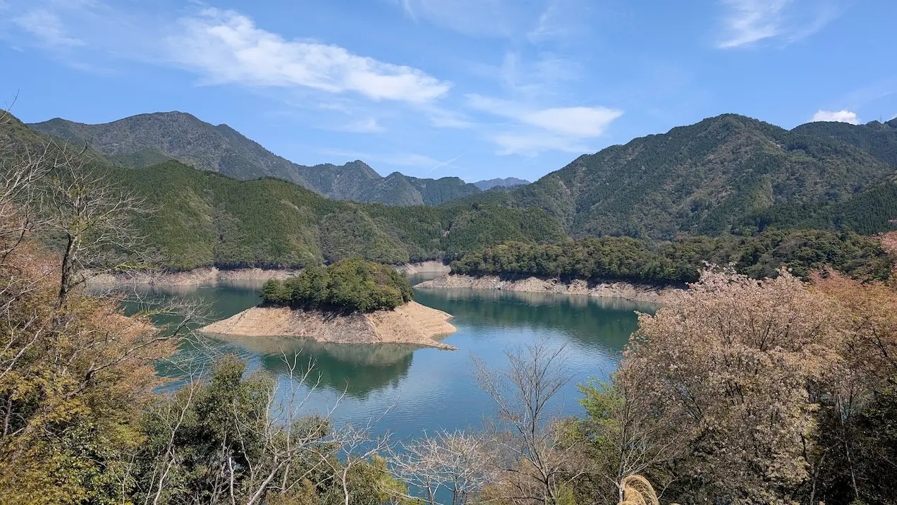 池原ダム展望台から見渡す、エメラルドグリーンのダム湖と新緑・桜が美しい山々の風景