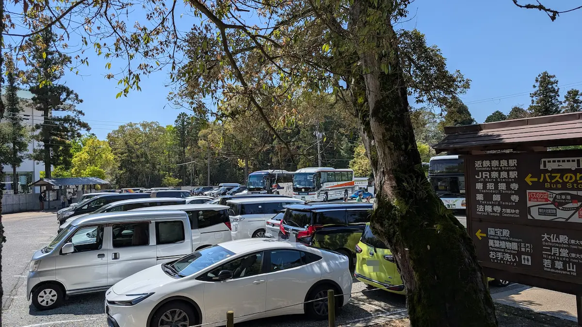 春日大社本殿前駐車場の平日午前中の混雑した様子と案内看板
