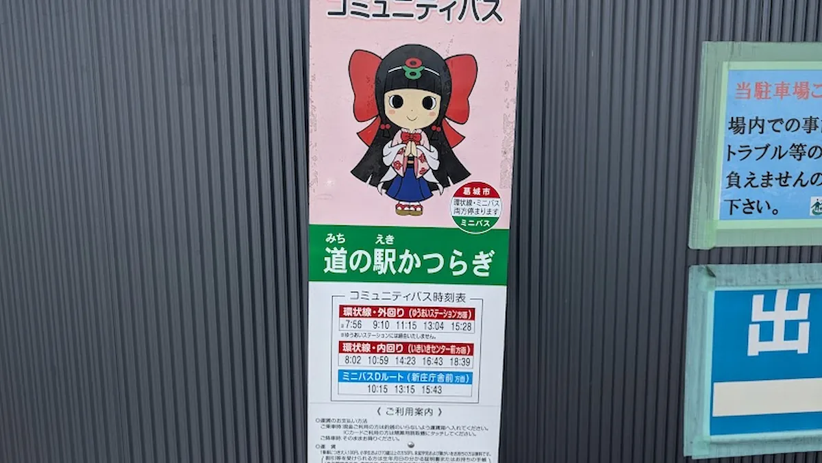 道の駅「かつらぎ」に設置されたコミュニティバスの時刻表。葛城市のキャラクター「蓮花ちゃん」が描かれ、環状線（外回り・内回り）やミニバスDルートの時間が記載されている