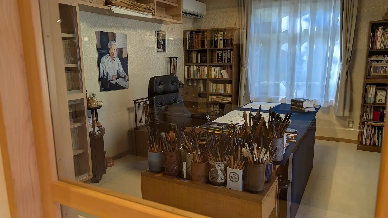 杉岡華邨記念館に展示されている、無数の筆や墨が並ぶ書道家の創作デスクのアップ