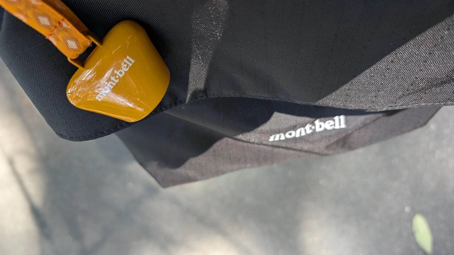 奈良県下北山村の池神社周遊歩道で、バックパックに取り付けられたモンベル製の熊鈴。周囲の緑を背景にした、安全な登山の備え。