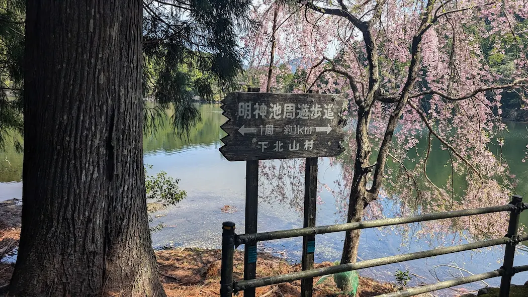 奈良県下北山村の明神池にある案内看板。「明神池周遊歩道 1周約1Km」と記された、味わいのある木製の看板。