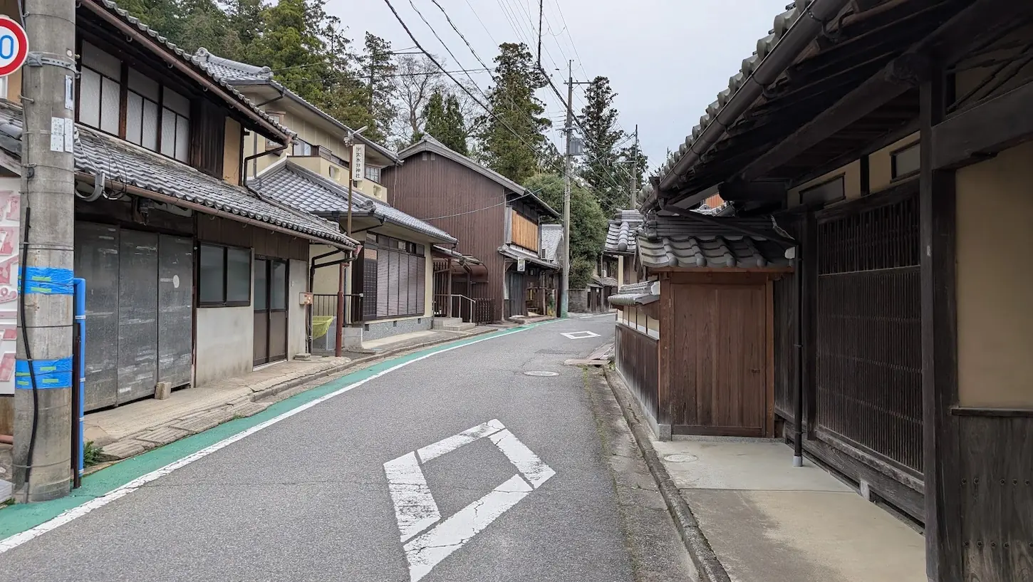 奈良県宇陀市、宇太水分神社のすぐ前を通る一方通行の細い道。古い木造家屋が並び、伝統的な街並みが残る風景。