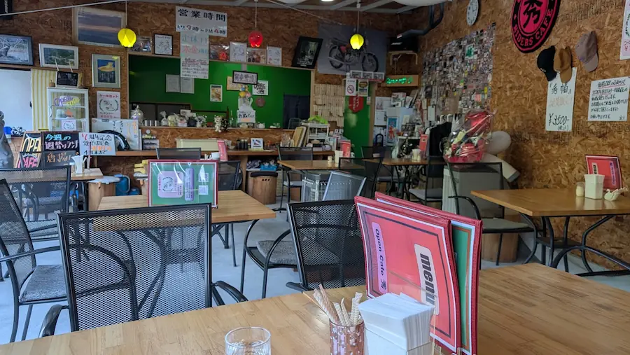 木の温もり溢れる壁に写真や雑貨が飾られた、Open cafe 秀（しゅう）の落ち着いた店内風景