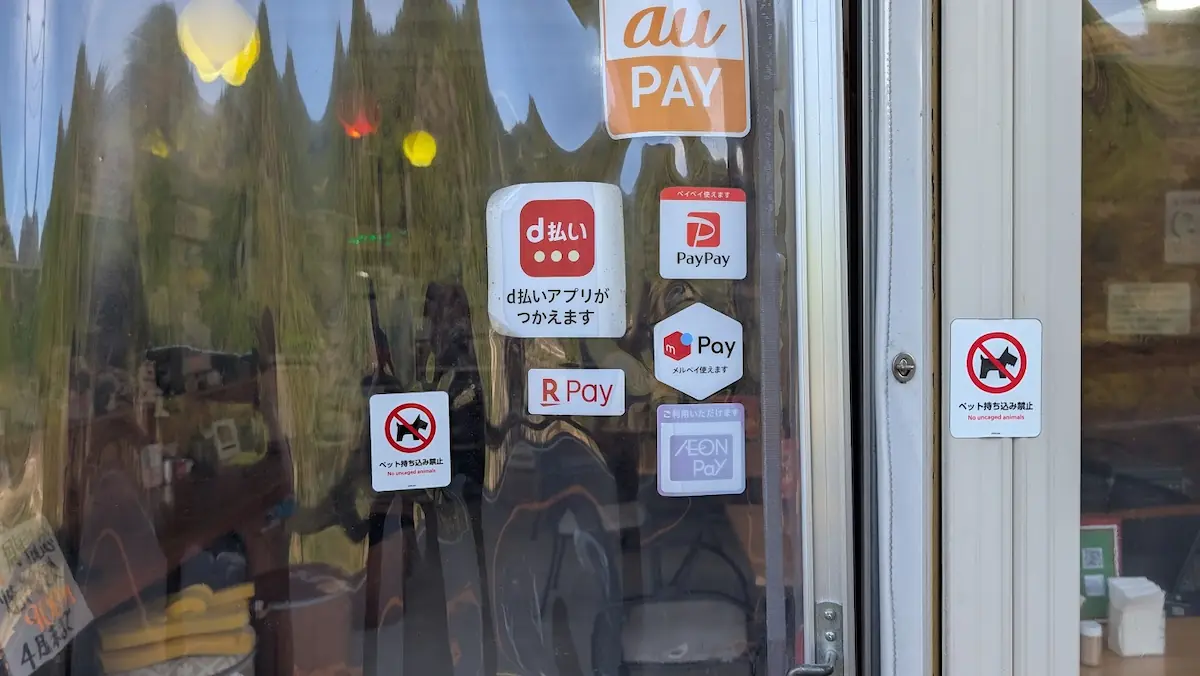 Open cafe 秀（しゅう）の入り口に貼られた、PayPayやd払いなどのQRコード決済対応ステッカーとペット持ち込み禁止の掲示