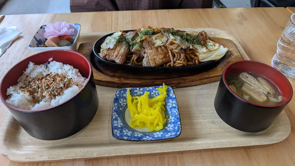 Open cafe 秀（しゅう）の、熱々の鉄板に盛られた焼きそば定食。ふりかけご飯、お味噌汁、小鉢のセット