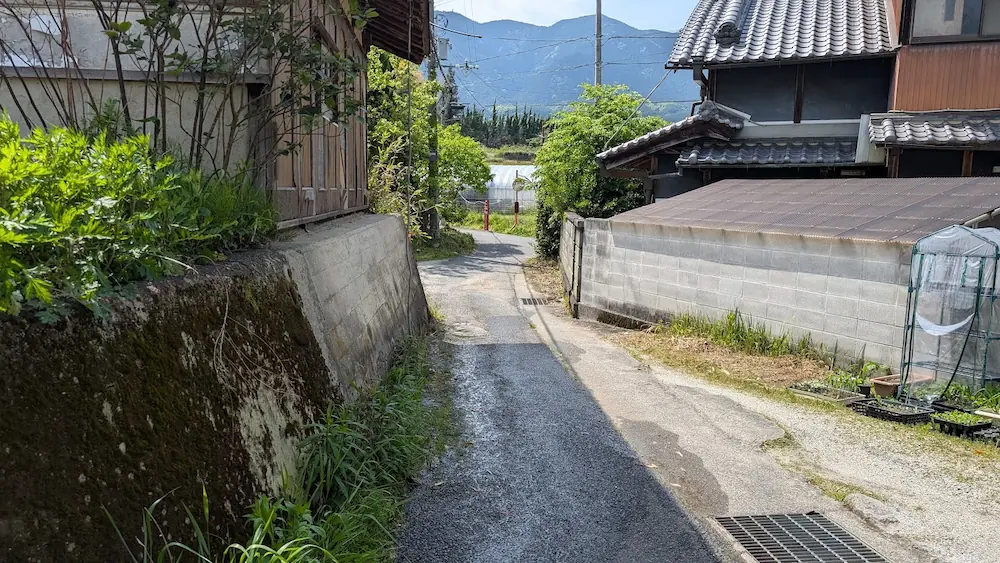 船宿寺の境内横駐車場から出口へ向かう、民家の白壁と石垣に挟まれた非常に狭いアスファルトの道