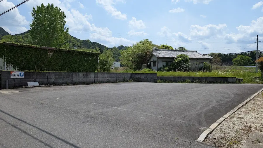 船宿寺の参道沿いにある、きれいに舗装された広々とした駐車場。周囲には豊かな緑と住宅が見える