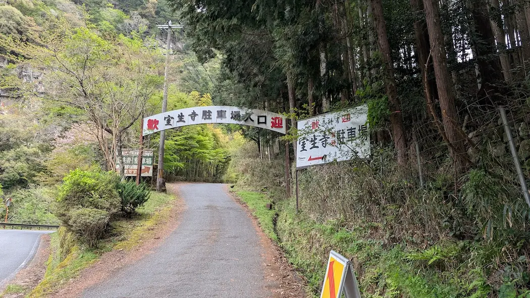 奈良・室生寺の有料駐車場入口にある「歓迎 室生寺駐車場入口」と書かれた白いアーチ型の看板と案内板