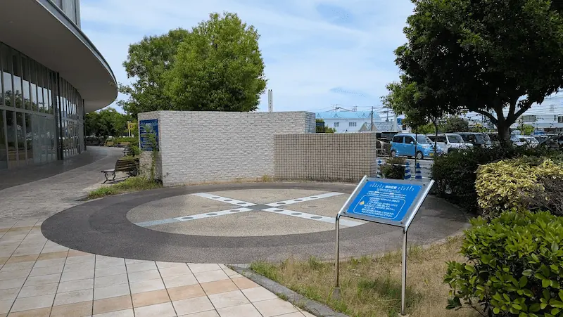 イオンモール橿原ノースモール外にある噴水広場。円形の地面と解説看板、周囲に植栽が整備されている様子。