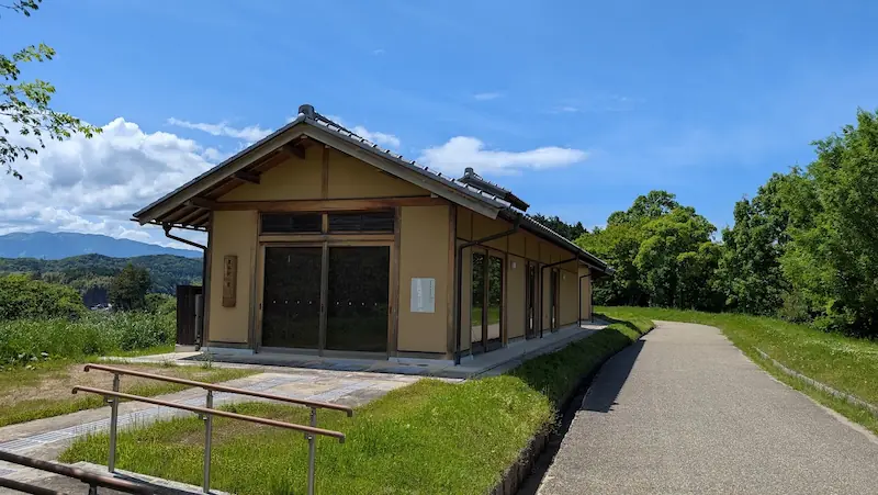 国営飛鳥歴史公園内にある「農体験小屋」。木造平屋建ての落ち着いた外観で、周囲には散策路が整備されている。
